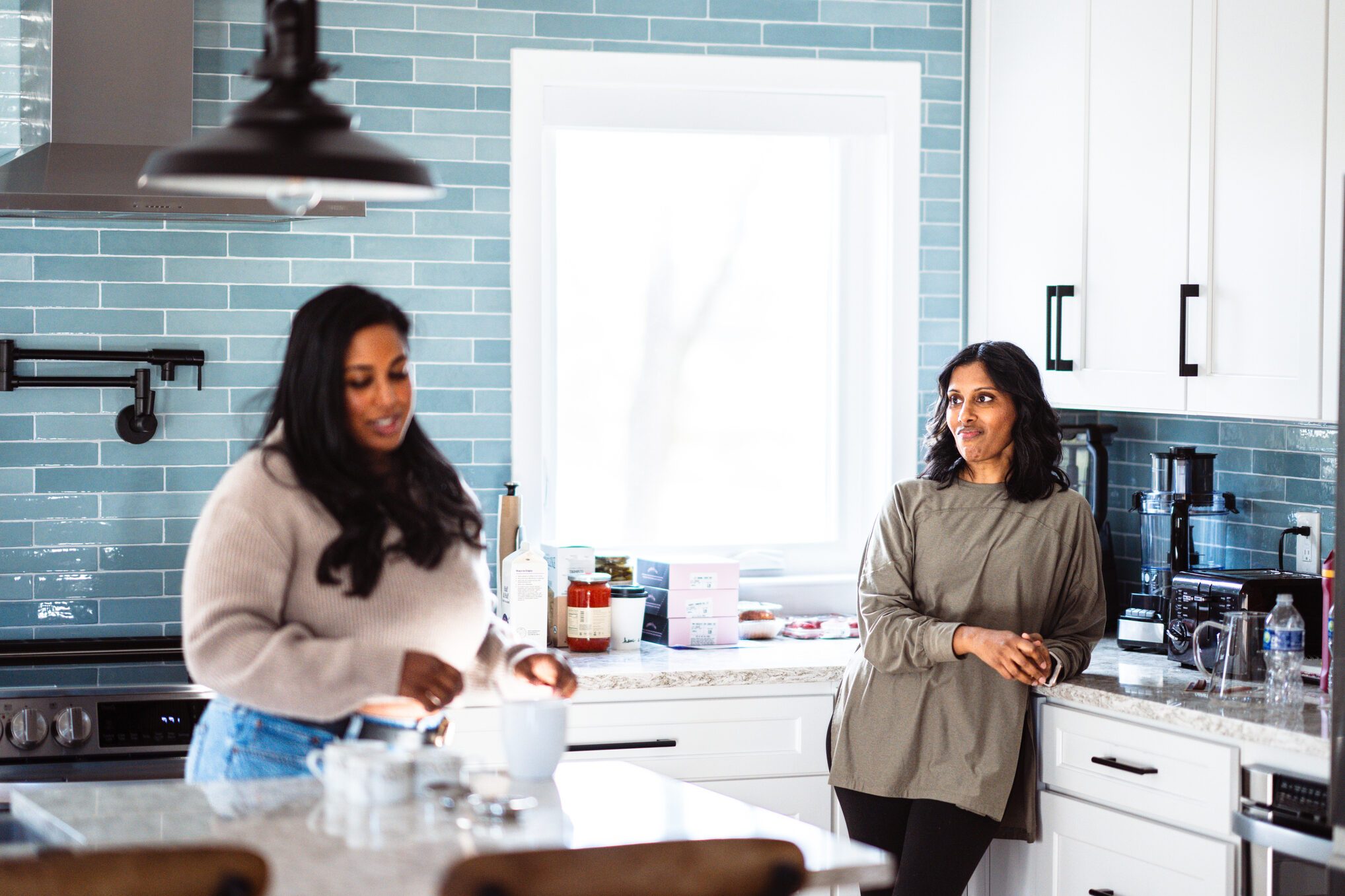 Adult sisters talking together in kitchen