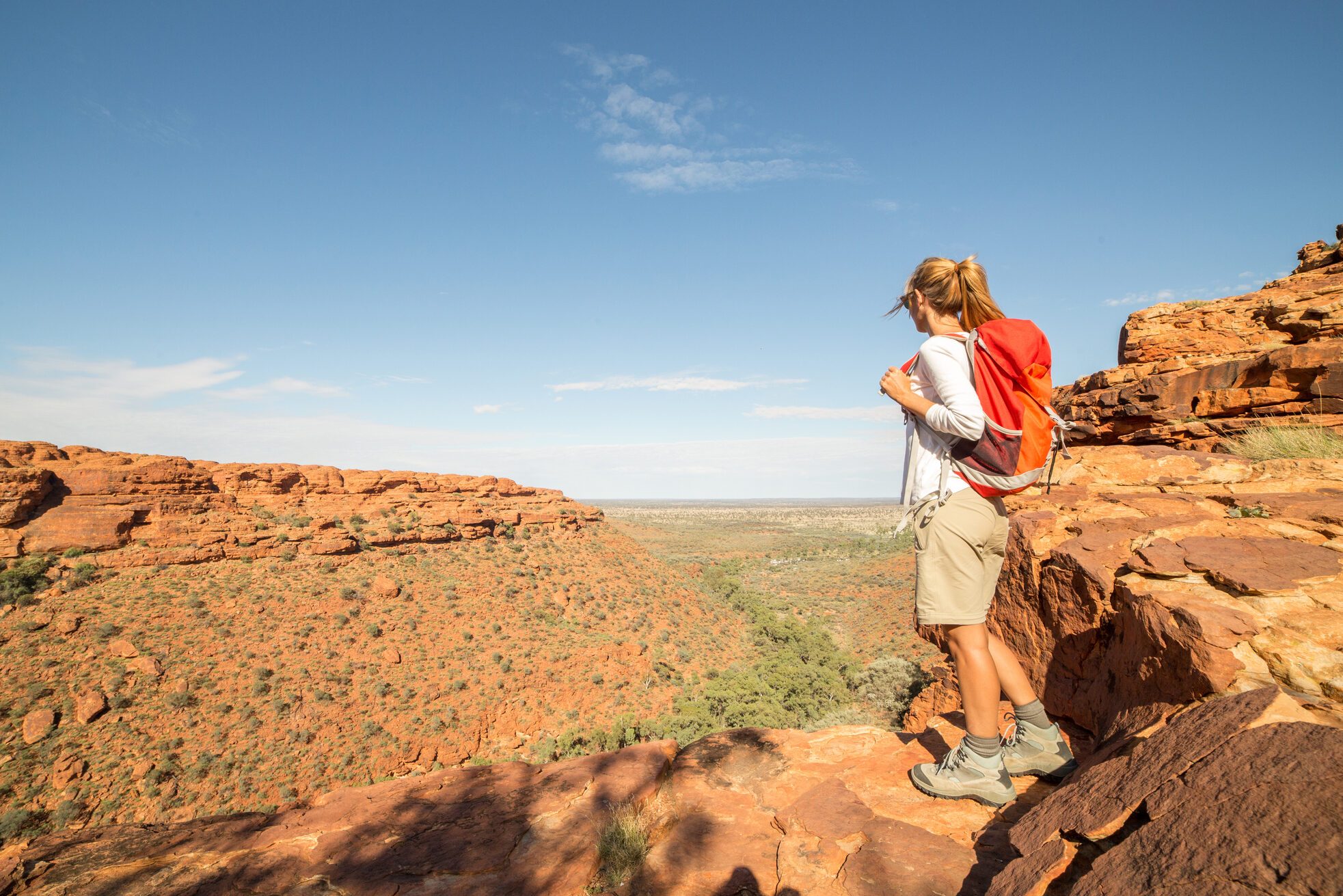 Hiker on mountain top contemplates view