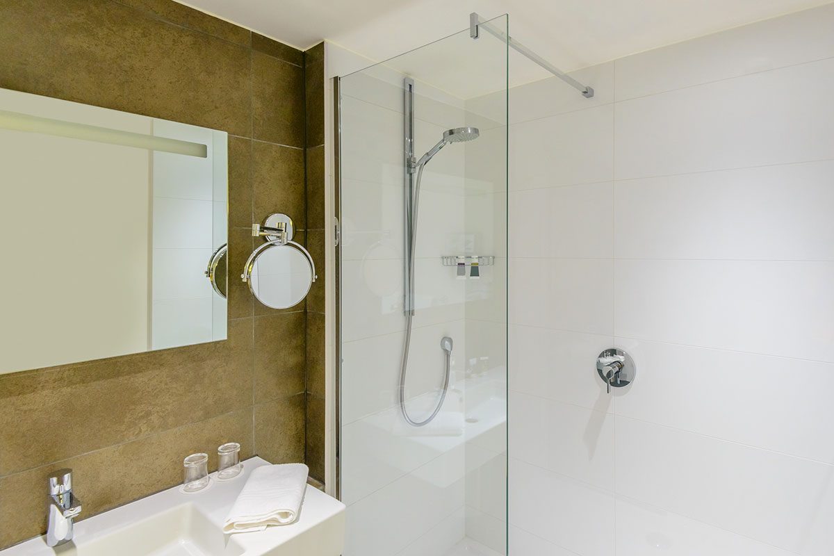 Fragment of a luxury bathroom with sink, mirror and towel on the wall.
