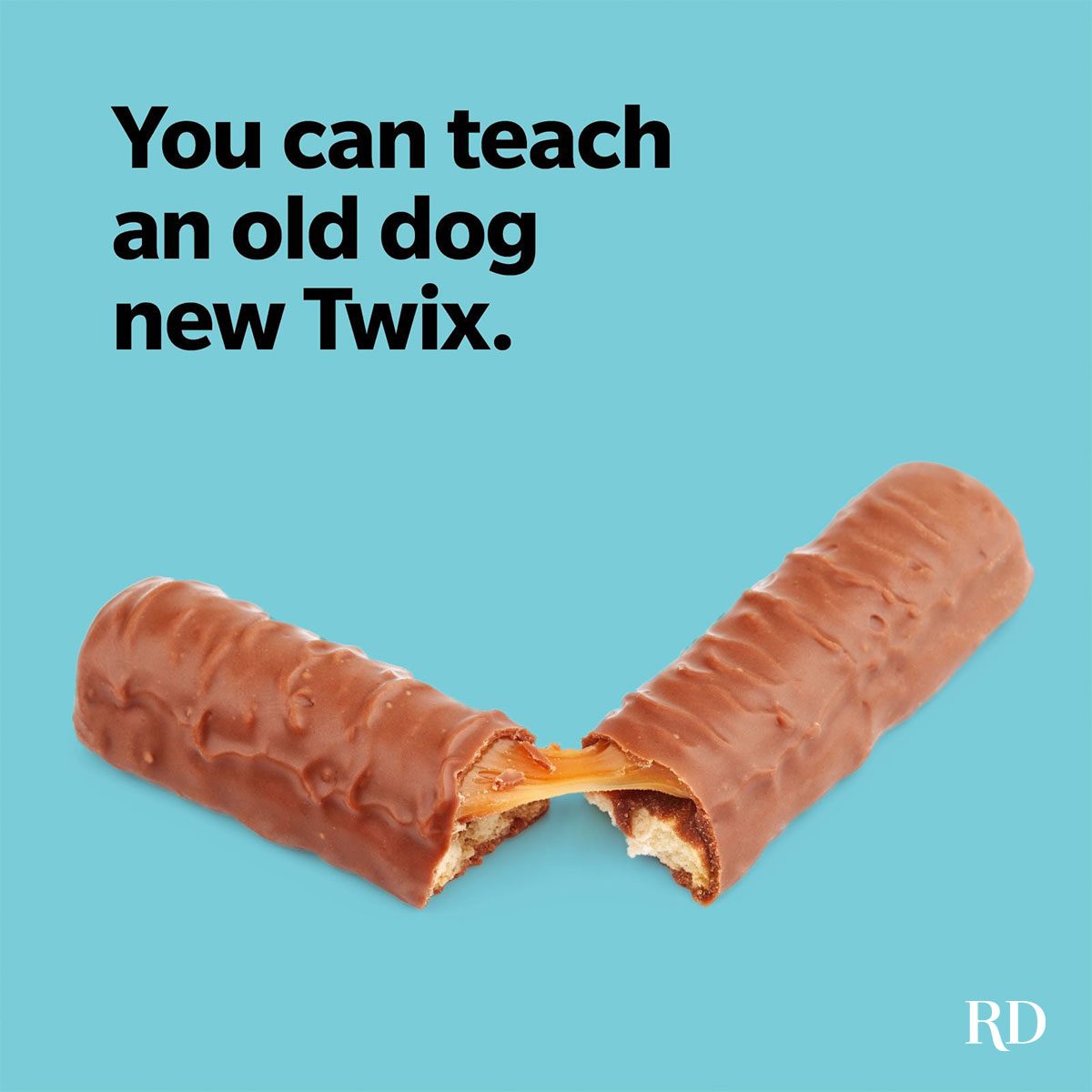 Twix bar breaks, revealing caramel, against a blue background with text: "You can teach an old dog new Twix." RD logo in the corner.