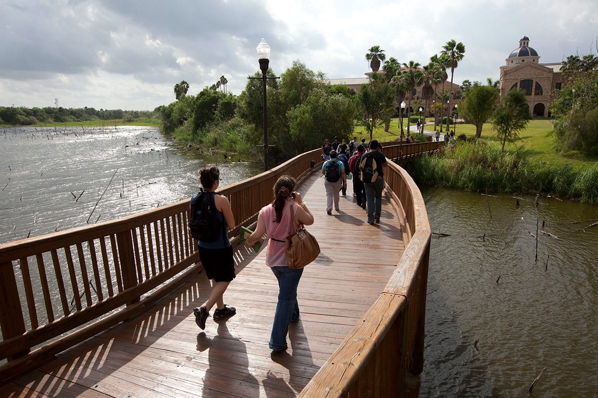 College students walk across the resaca (oxbow lake) that once was the Rio Grande River at the University of Texas-Brownsville and Texas Southmost College campus