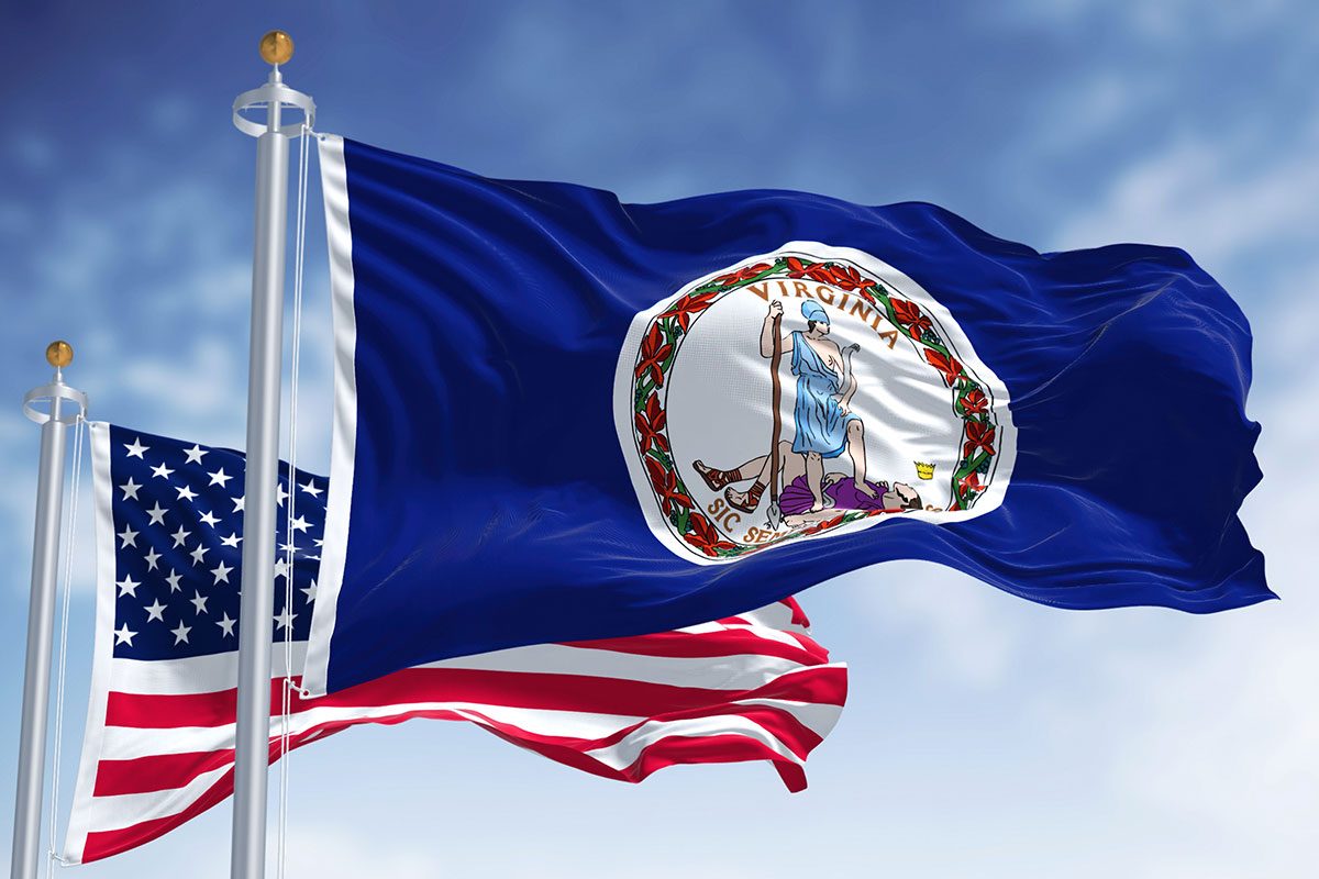 he Virginia state flag waving along with the national flag of the United States of America