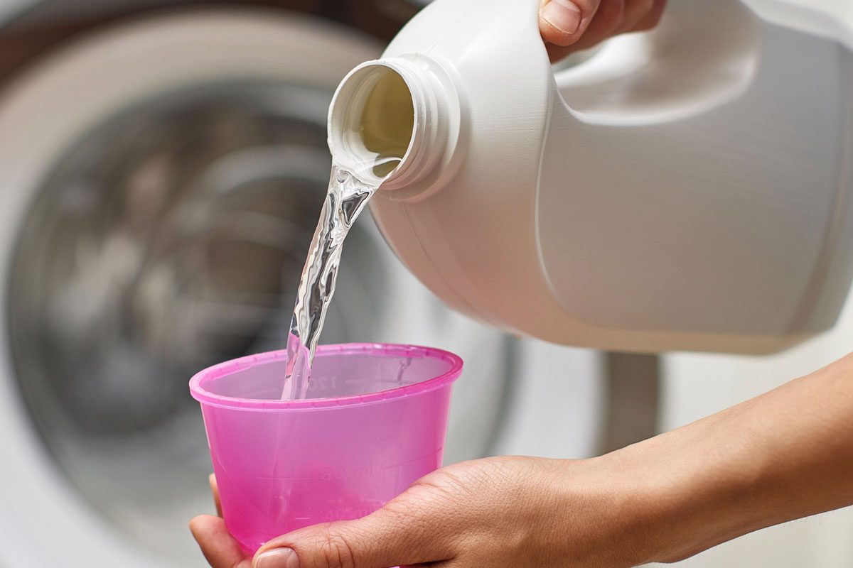 Woman Pours Liquid Laundry Detergent Into Plastic Cap