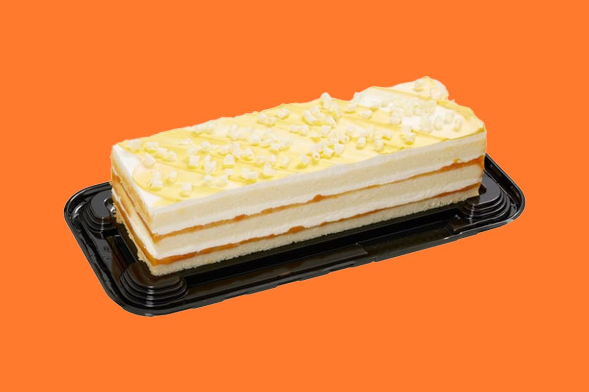 Peaches and cream cake from Costco on an orange background