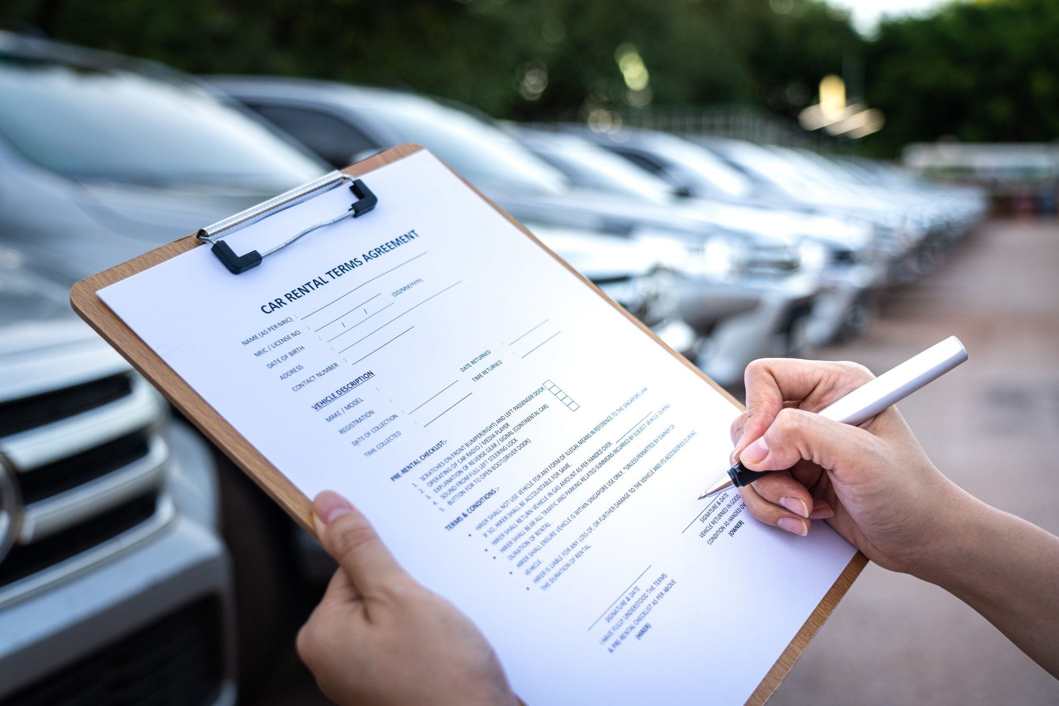 Signing on the agreement term of car rental service - Business and transportation service concept.